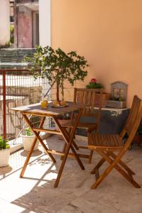 un patio con tavolo e sedie in legno e un albero di The Village Cottage - Benitses a Benitses