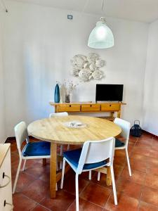 una sala da pranzo con tavolo e sedie in legno di Il Gabbiano a Santa Teresa di Gallura