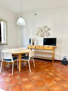 a dining room with a table and a tv at Il Gabbiano in Santa Teresa Gallura