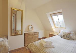 een slaapkamer met een bed, een spiegel en een dressoir bij Ash in Lowestoft