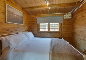 a bedroom with a bed in a wooden cabin at Old Cottage The Log Cabin in Bacton