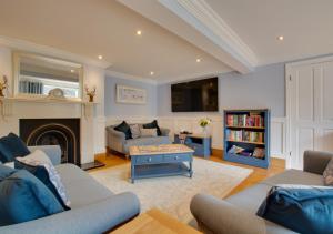 a living room with two couches and a fireplace at Old Cottage The Log Cabin in Bacton