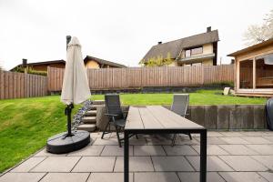 um guarda-sol, uma mesa e cadeiras num pátio em Eifel-resort em Waxweiler