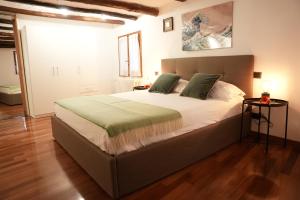 een slaapkamer met een groot bed met groene kussens bij Janua Major in Cernobbio