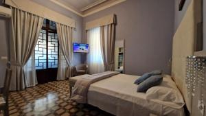 a bedroom with a bed and a tv on the wall at Hotel Giardino in Lido di Camaiore
