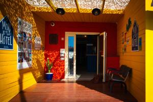a hallway with a red and yellow wall and a door at Mon P'tit Hôtel in Le Grau-dʼAgde