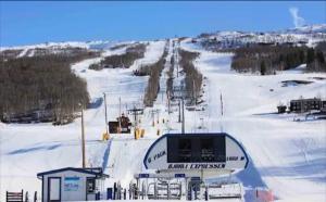 a ski lift on a snow covered ski slope at Leilighet på Bjorli Apartment in Bjorli