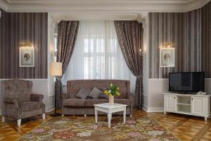 a living room with a couch and a tv at Modern Art Hotel in Lviv