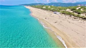 uma vista sobre uma praia com água azul-turquesa em Residence surrounded by greenery with swimming pool in Badesi just 300 meters from the sea em Badesi