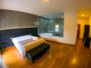 1 dormitorio con 1 cama y una gran ventana de cristal en Hotel Beira Rio, en Piraju