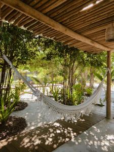 a hammock under a pergola in a garden at Pousada Refazenda in Corumbau