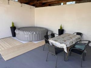 a patio with a table and chairs and a hot tub at Apartman Žanić Ogulin in Ogulin