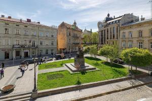 a city with a statue in the middle of a street at Modern Art Hotel in Lviv