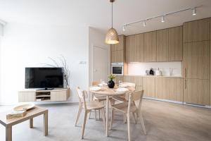 uma cozinha e sala de jantar com mesa e cadeiras em 2HomeRent Apartamenty Urocza 10 em Bydgoszcz