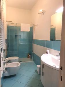 Un baño con lavabo, inodoro y ducha. en Cairoli Home, en Rapallo