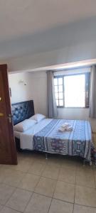 a bedroom with a large bed with a window at Pousada Mar Dos Anjos in Arraial do Cabo