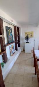 a room with paintings on the wall and benches at Pousada Mar Dos Anjos in Arraial do Cabo