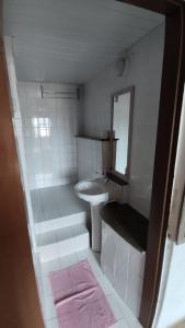 a small white bathroom with a sink and a mirror at Pousada Mar Dos Anjos in Arraial do Cabo