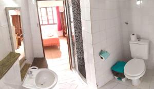 a white bathroom with a toilet and a sink at Pousada Mar Dos Anjos in Arraial do Cabo