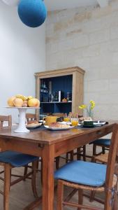 una mesa de madera con comida encima en Le jardin de Gassiot, en Saint-Quentin-de-Baron