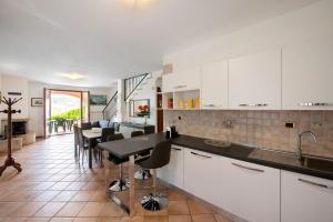 uma cozinha com armários brancos e um balcão preto em Villetta Oleandri em Soiano del Lago