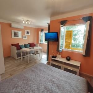 ein Schlafzimmer mit einem Bett und ein Wohnzimmer in der Unterkunft Bonrila Sun Apartman in Zamárdi