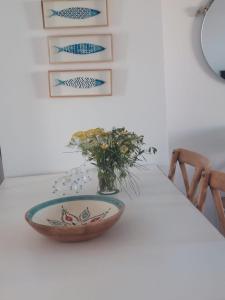 un tazón en una mesa con un jarrón de flores en NEW!! Bonito adosado en Zahara de los Atunes, en Zahara de los Atunes
