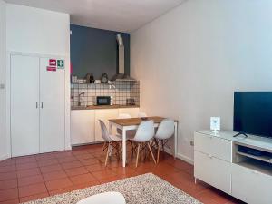 a kitchen with a table and chairs and a television at Imperial Douro Apartamento 1 in Peso da Régua