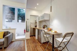 cocina y sala de estar con mesa y sillas en 101- Beautiful apartment near champs elysees en París