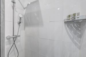 baño blanco con ducha con cabezal de ducha en 101- Beautiful apartment near champs elysees en París