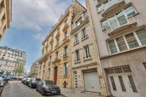 un edificio con coches aparcados al lado de una calle en 101- Beautiful apartment near champs elysees en París