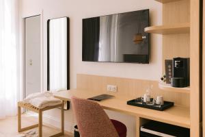 a room with a desk with a laptop and a mirror at H&ocirc;tel Majestic in Bordeaux