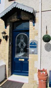 Una puerta azul de una casa con un cartel. en Westward B&B, en Newquay