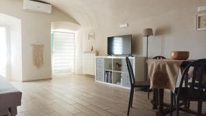 a living room with a table and a tv on top at Nene's Home in Sanremo