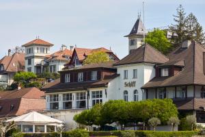 a large white building with a lot of houses at Hotel Schiff am See in Murten