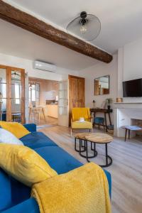een woonkamer met een blauwe bank en een tafel bij Escapade à Sanary au Cœur du Village in Sanary-sur-Mer
