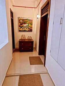 einen Flur mit einer Tür und einem Gemälde an der Wand in der Unterkunft Pristine residence in Dehiwala
