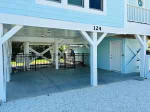a front porch of a blue house with the number at No Egrets condo in Holden Beach