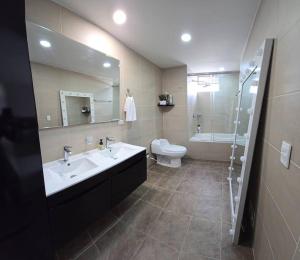 een badkamer met een wastafel, een toilet en een spiegel bij Exclusivo penthose in Ibagué