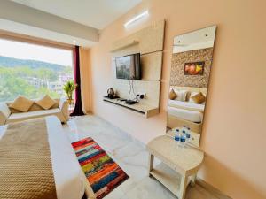 een woonkamer met een grote spiegel en een slaapkamer bij Hotel Springs in Haridwār