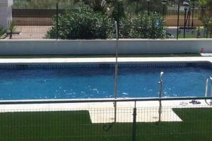 a large blue swimming pool with a fence around it at Teatinos Atico Penthouse Pool WiFi Parking in Málaga