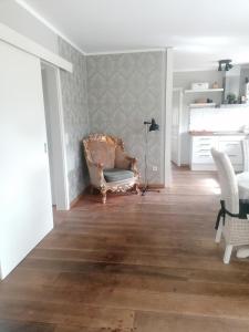 uma sala de estar com uma cadeira e uma mesa em Haus Alma 1 em Wardenburg