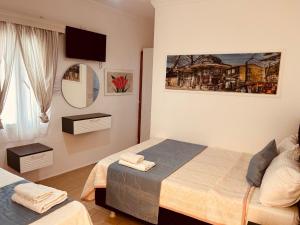 a bedroom with two beds and a tv on the wall at Devran Pansiyon in Bodrum City