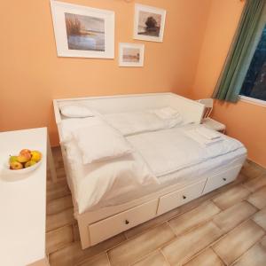 a bed in a room with a bowl of fruit at Bonrila Sun Apartman in Zamárdi