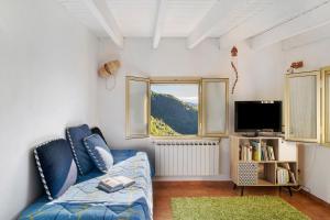 sala de estar con sofá azul y ventana en House of silence en Badalucco