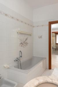 Baño blanco con bañera y lavamanos en Spacious Exclusive Apartment en Pioltello