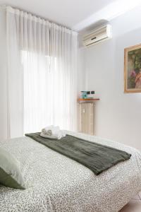 a white bedroom with a bed with a window at Spacious Exclusive Apartment in Pioltello
