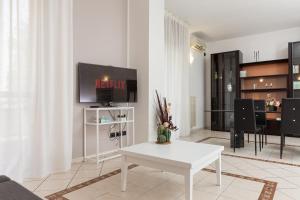 a living room with a white table and a tv at ArtStay Exclusive Apt Linate, Parking, Terrace AC in Pioltello