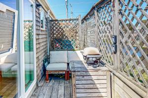 a screened in porch with a chair and a grill at Cozy Cape Condo in Provincetown