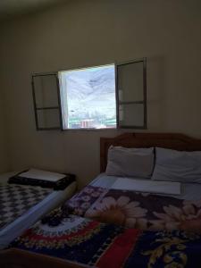 a bedroom with two beds and a window at hotel atlas in Imilchil